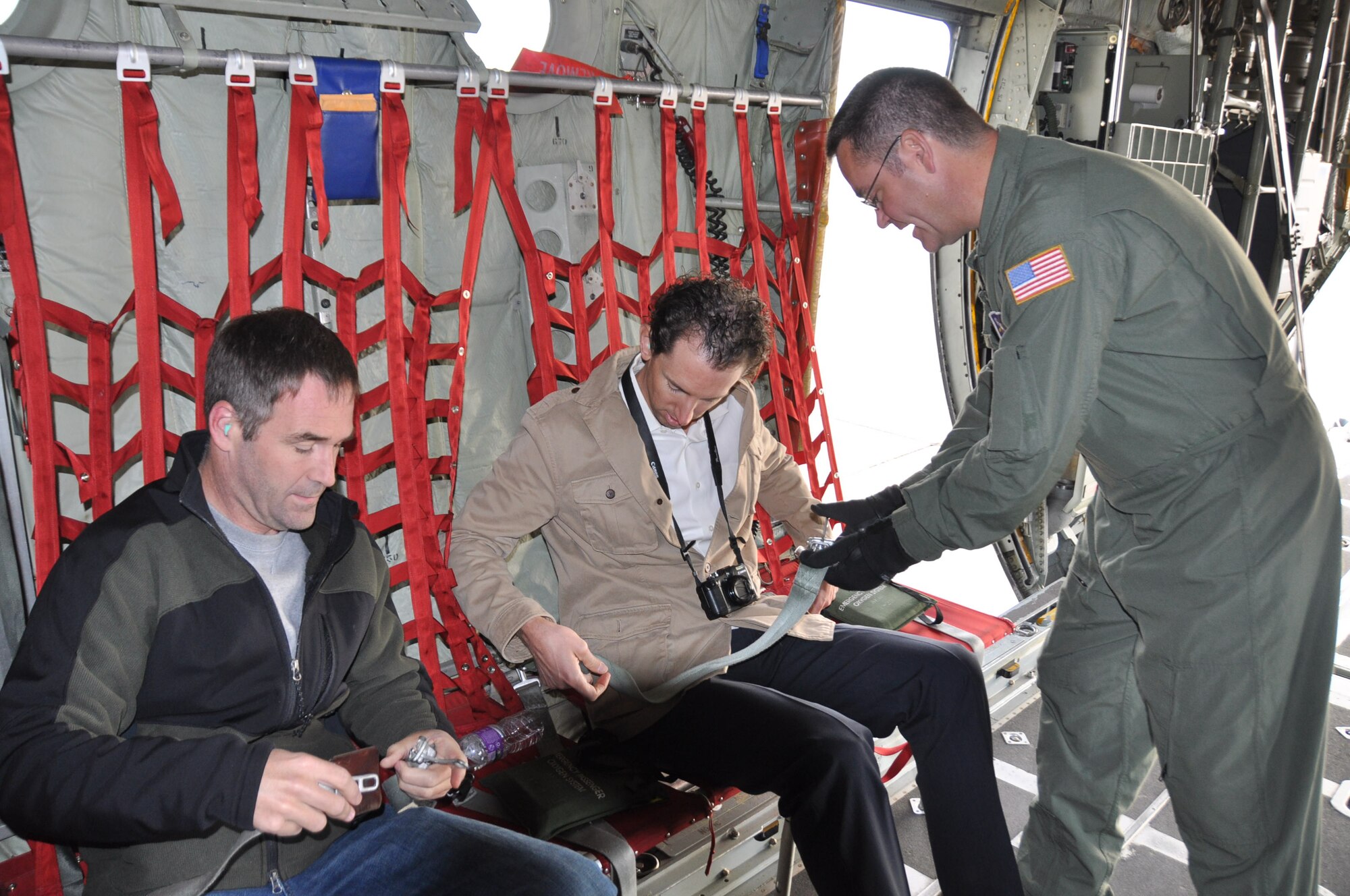 Master Sgt. Jim Courneya, 96th Airlift Squadron, assists Drs. David Willis, (right) and Tim Rajtora fasten their seatbelts for the C-130 Civic Leader Flight Sept. 14.  Leaders also attended the Base Community Council meeting after the flight. (Air Force Photo/Capt. S.J. Brown)