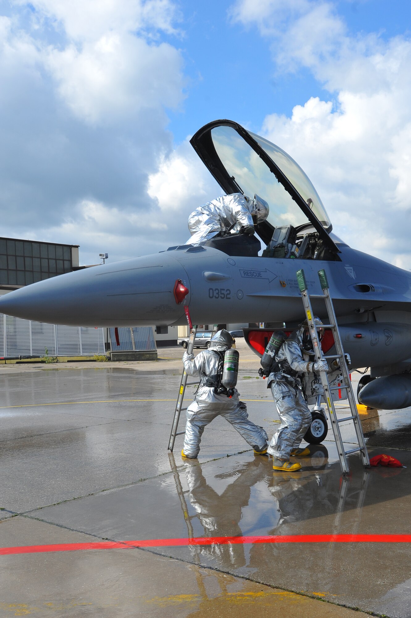 SPANGDAHLEM AIR BASE, Germany – Airmen assigned to the 52nd Civil Engineer Squadron Fire Department, simulate rescuing a trapped pilot from a burning aircraft during a capabilities demonstration for 52nd Fighter Wing leadership here Sept. 19. The demonstration showcased the fire department’s ability to protect Airmen and assets. (U.S Air Force photo/Airman 1st Class Dillon Davis)
