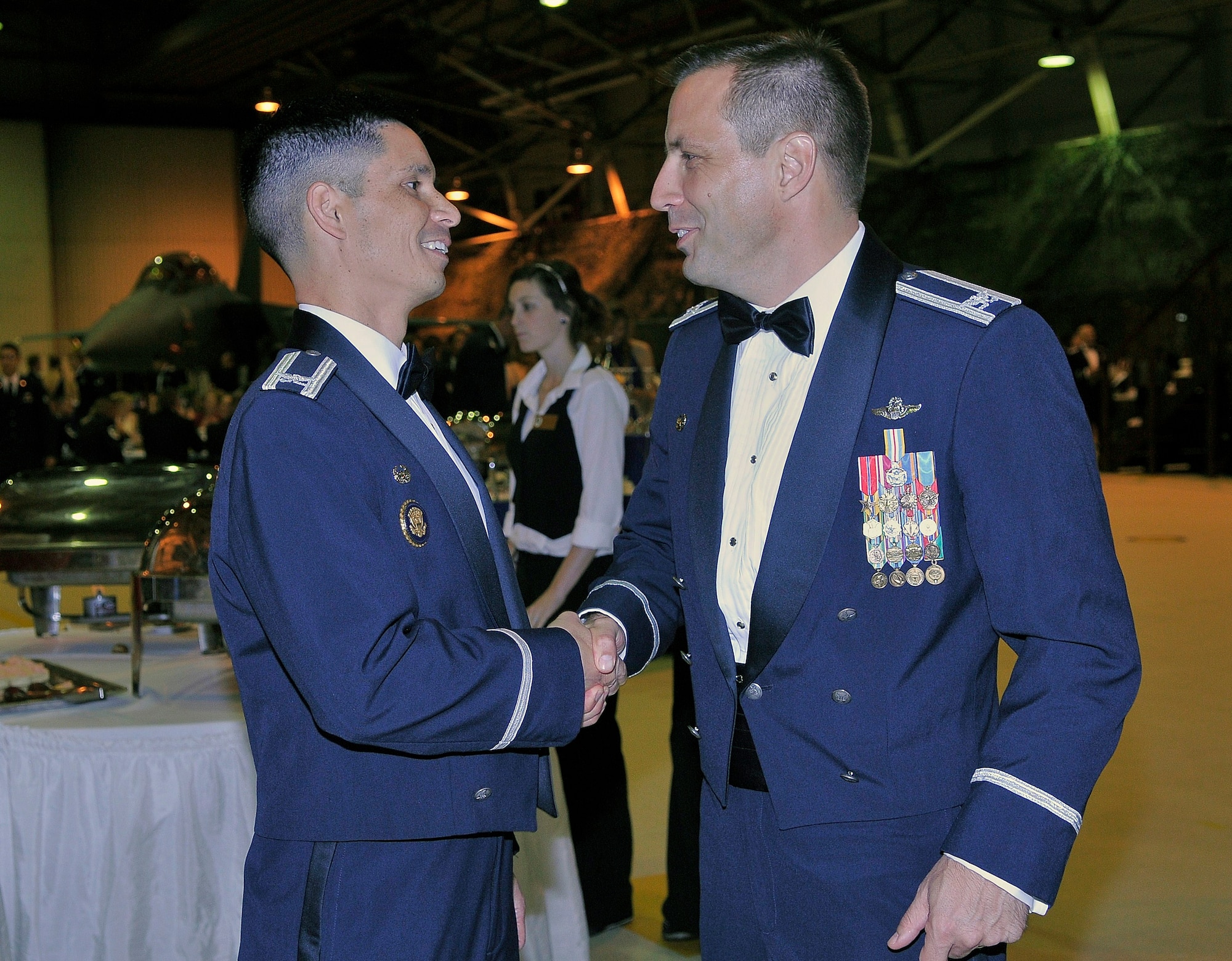 ROYAL AIR FORCE LAKENHEATH, England - Col. John Quintas, 48th Fighter Wing commander, shakes hands with Col. Christopher Kulas, 100th Air Refueling Wing commander, during the Air Force Ball in Hangar 7 on Sept. 17, 2011.  More than 600 people attended the event, which highlighted the different decades and the history of RAFs Lakenheath and Mildenhall.  (U.S. Air Force photo by Staff Sgt. Connor Estes)