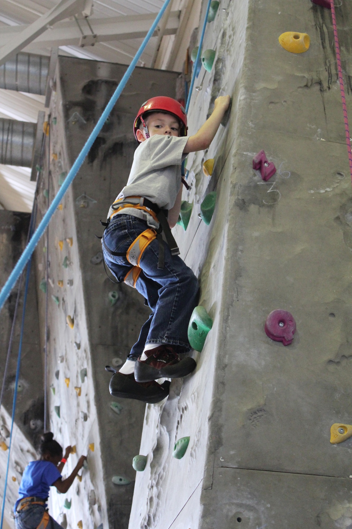 ROYAL AIR FORCE LAKENHEATH, England - Tristan Estes (7) climbs the rock wall at the RAF Lakenheath Youth Center during the World Wide Day of Play on Sept. 17, 2011.  The World Wide Day of Play is an annual event designed to encourage kids and parents to turn off the television, get out of the house, be active and play.  More than 450 Airmen and family members attended the event.  (U.S. Air Force photo by Staff Sgt. Connor Estes)