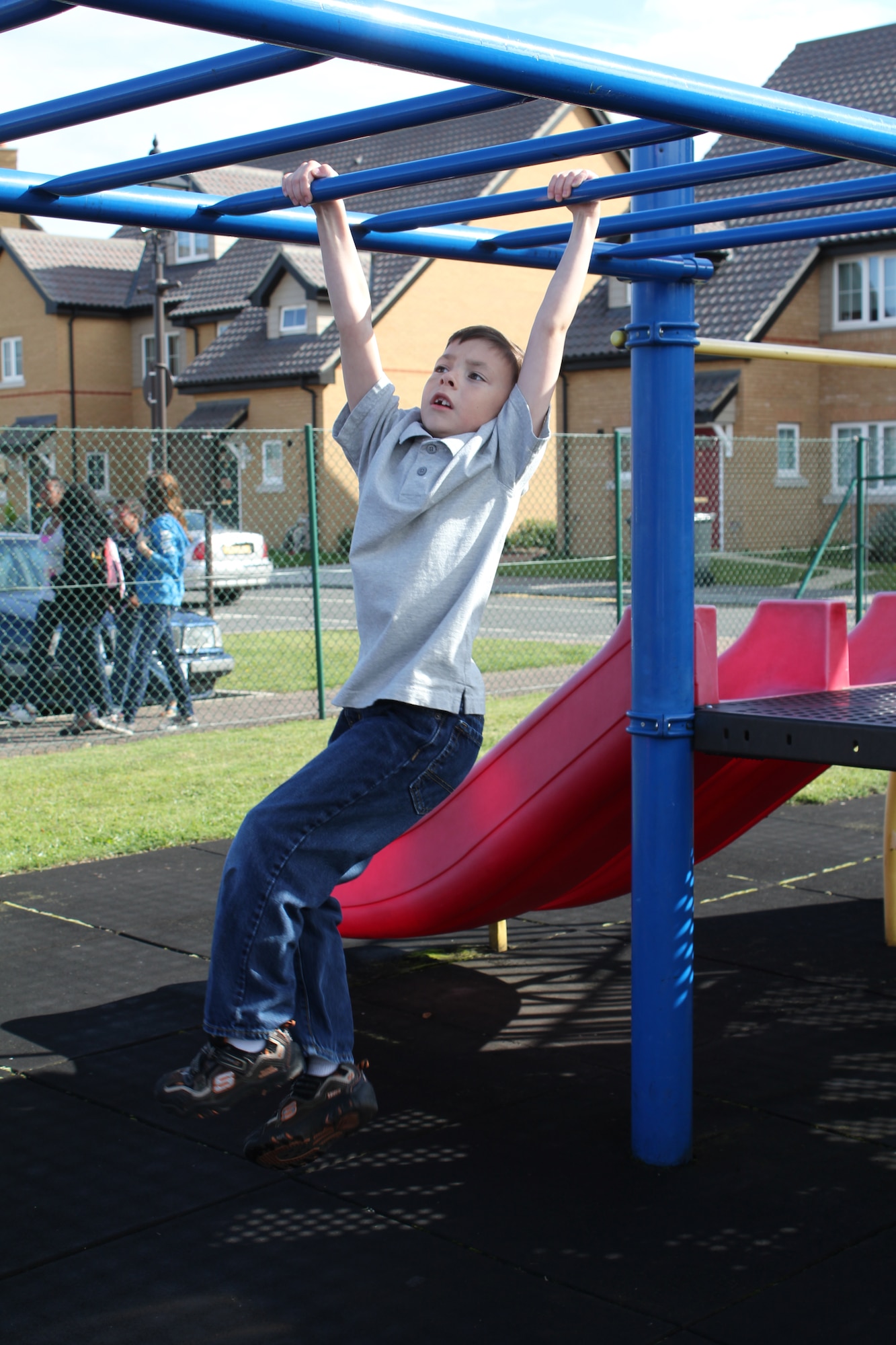 ROYAL AIR FORCE LAKENHEATH, England - Tristan Estes (7) swings on monkey bars at the RAF Lakenheath Youth Center during the World Wide Day of Play on Sept. 17, 2011.  The World Wide Day of Play is an annual event designed to encourage kids and parents to turn off the television, get out of the house, be active and play.  More than 450 Airmen and family members attended the event.  (U.S. Air Force photo by Staff Sgt. Connor Estes)
