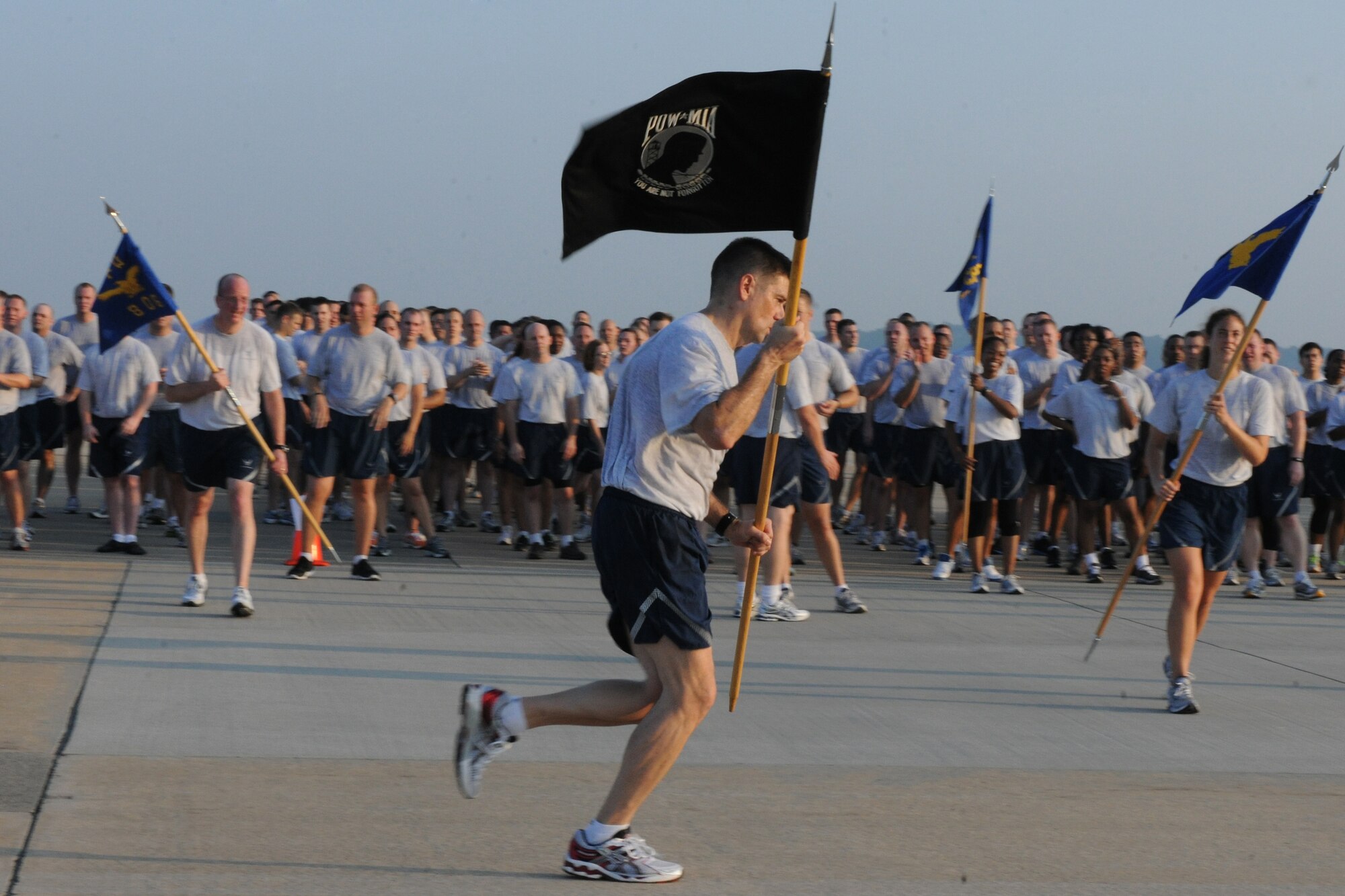 KUNSAN AIR BASE, Republic of Korea -- Chief Master Sgt. Scott Delveau, 8th Fighter Wing command chief, runs with the POW/MIA flag after the warrior run here Sept. 16. Delveau along with squadron first sergeants ran the first leg of the 24-hour run in remembrance of the POW/MIA servicemembers. (U.S. Air Force photo/Senior Airman Brittany Y. Bateman)


