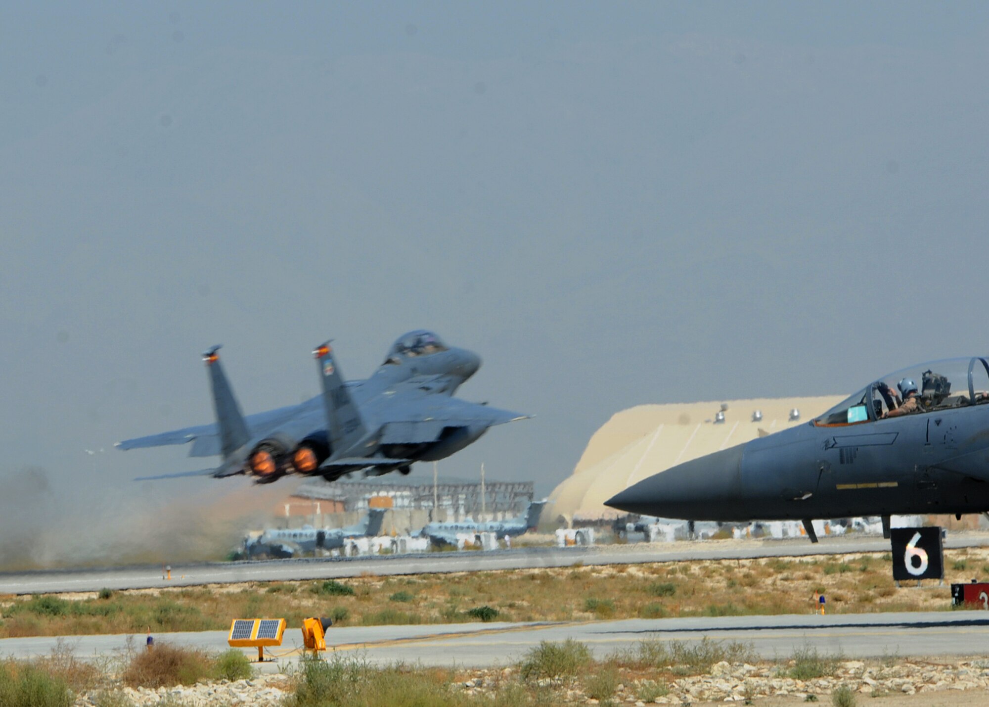 BAGRAM AIRFIELD, Afghanistan -- An F-15E Strike Eagle from the 389th Expeditionary Fighter Squadron takes off as a wingman taxies out to the runway in support of Operation Enduring Freedom here Sep. 20, 2011. The F-15 is a dual-role fighter designed to perform air-to-air and air-to-ground missions. It can penetrate enemy defense and outperform and outfight any current enemy aircraft. (U.S. Air Force photo/ Senior Airman Krista Rose)
