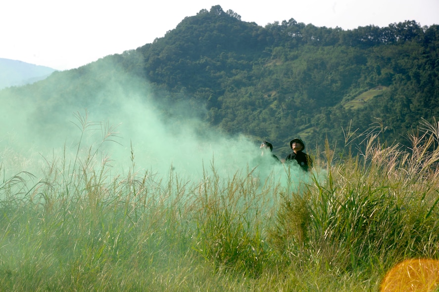 CHEONGJU, Republic of Korea -- Republic of Korea Air Force survival, evasion, resistance and escape instructors pop green smoke as a marker for jumpers to know where to land here Sept. 15. The crews conducted aerial training missions to help keep themselves mission ready and qualified to ensure special operations forces members are up to date with their training requirements. (U.S. Air Force photo/Staff Sgt. Rasheen A. Douglas)
