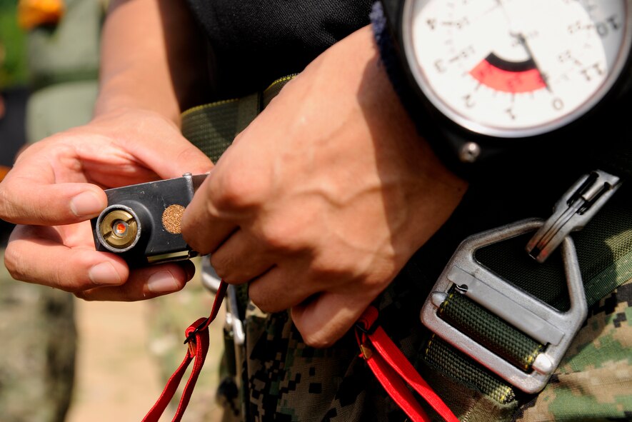 CHEONGJU, Republic of Korea -- A Republic of Korea Air Force survival, evasion, resistance and escape instructor performs operational checks on his equipment before his jump here Sept. 15. The crews conducted aerial training missions to help keep themselves mission ready and qualified to ensure special operations forces members are up to date with their training requirements. (U.S. Air Force photo/Staff Sgt. Rasheen A. Douglas)