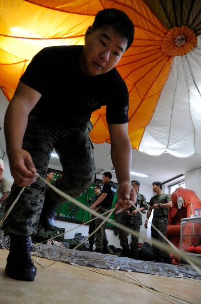CHEONGJU, Republic of Korea -- A Republic of Korea Air Force survival, evasion, resistance and escape instructor from their Intelligence Training Squadron packs up a parachute here Sept. 15. The U.S. Air Force and ROKAF performed a jump together helping improve relationships with one another and stimulate a continued bilateral partnership on the peninsula. (U.S. Air Force photo/Staff Sgt. Rasheen A. Douglas)