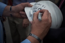 NEW YORK --  Sgt. Dakota Meyer, the first living Marine to be awarded the Medal of Honor for actions since Vietnam, signs a construction worker's hard hat while touring the National September 11 Memorial & Museum after speaking at a ceremony, here, Sept. 21. The two black bracelets he wears are inscribed with the names of the three Marines and sailor who died in the Sept. 9, 2009 battle referenced in Meyer's Medal of Honor citation. During his speech he told the audience of mostly veterans, firefighters, police and construction workers, "people have been calling me a hero a lot lately, but you are the real heroes... If this is what being a hero feels like, you can have it." For more information, visit www.dakotameyer.com. (Official Marine Corps photo by Sgt. Randall A. Clinton / RELEASED)