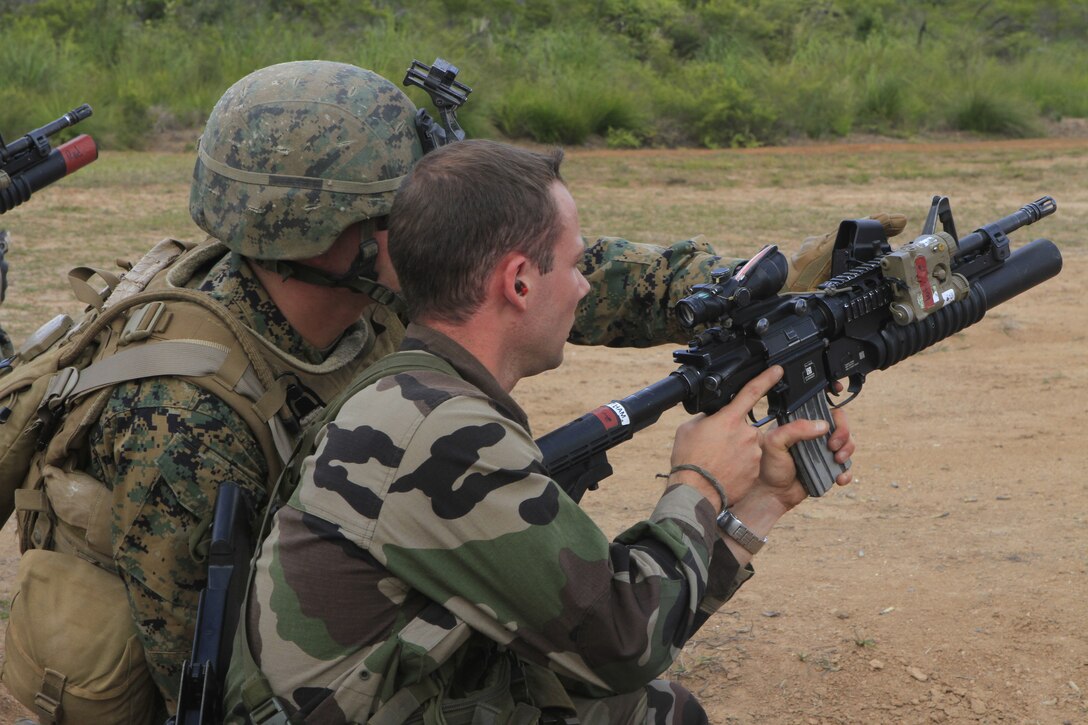 A U.S. Marine with 2nd Battalion, 3rd Marine Regiment, instructs a French armed forces Marine on how to use an M203 grenade launcher at Plum Base Range, New Caledonia, France, Sept. 22, 2011. The 2/3 is participating in Exercise AMERICAL 2011, a platoon-level combat arms combined exchange between the French armed forces, New Caledonia and U.S. Marines with the purpose of maintaining a high level of interoperability, enhancing military-to-military relations and improving mutual combat capabilities with French allies.