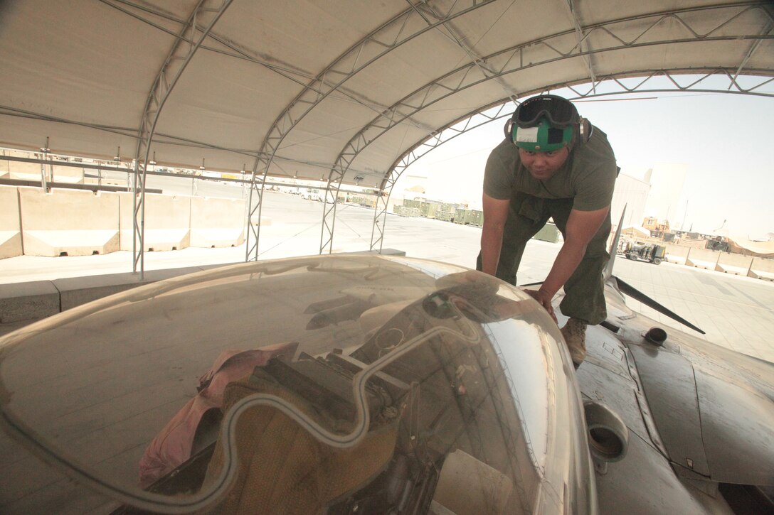 Cpl. Joseph Aguon, a Marine Attack Squadron 513 ejection seat mechanic and Santa Rita, Guam, native, closes the hatch on an AV-8B Harrier at Kandahar Airfield, Afghanistan. Ejection seat mechanics support the squadron’s aviation life support systems division.
