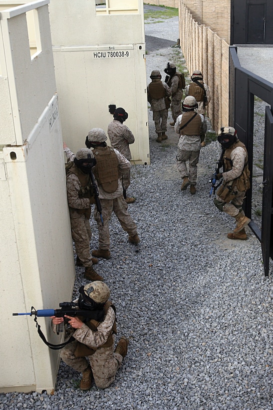Military policemen practice entering a compound during the company’s final exercise of the year in Combat Town in the Central Training Area Sept. 22. The Marines entered and cleared a house that sheltered possible armed persons and used proper techniques they practiced throughout the year. The military policemen are with Military Police Company, Marine Wing Support Group 17, 1st Marine Aircraft Wing, III Marine Expeditionary Force.
