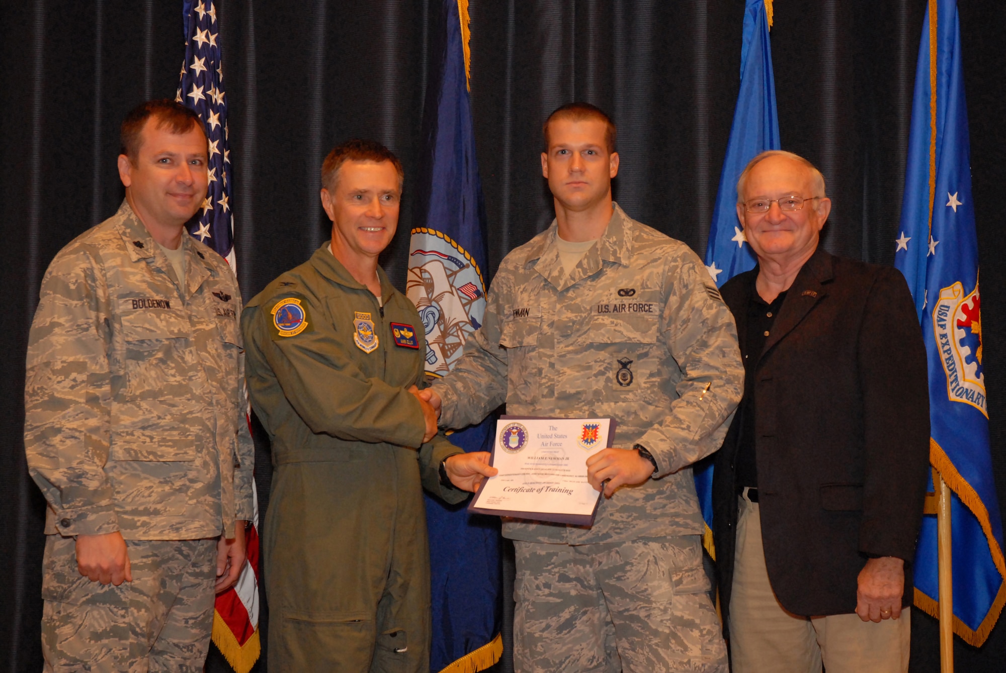 The 2,000th security forces Phoenix Raven, Senior Airman William Newman Jr. (right-center), from the 811th Security Forces Squadron at Joint Base Andrews, Md., receives his certificate of completion from the Phoenix Raven Training Course from Col. Mark Ellis, U.S. Air Force Expeditionary Operations School Commandant (left-center), accompanied by retired Col. Lawrence "Rocky" Lane (right) and Lt. Col. Rhett Boldenow (left), 421st Combat Training Squadron commander, during Raven graduation ceremonies at the U.S. Air Force Expeditionary Center on Sept. 22, 2011, at Joint Base McGuire-Dix-Lakehurst, N.J.  (U.S. Air Force photo/Tech. Sgt. Paul R. Evans)