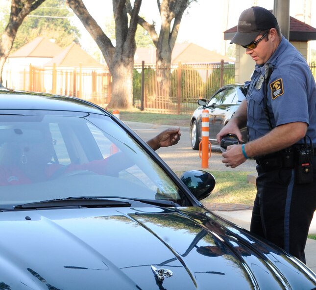 John Kennedy, contract security guard on Barksdale Air Force Base, La., scans an identification card Sept. 22 to ensure unauthorized personnel don?t gain access to the base.  Beginning Oct. 1, the new civilian security officers and military police will stand post at all of the gates. (U.S. Air Force photo/Airman 1st Class Andrea F. Liechti) (RELEASED)