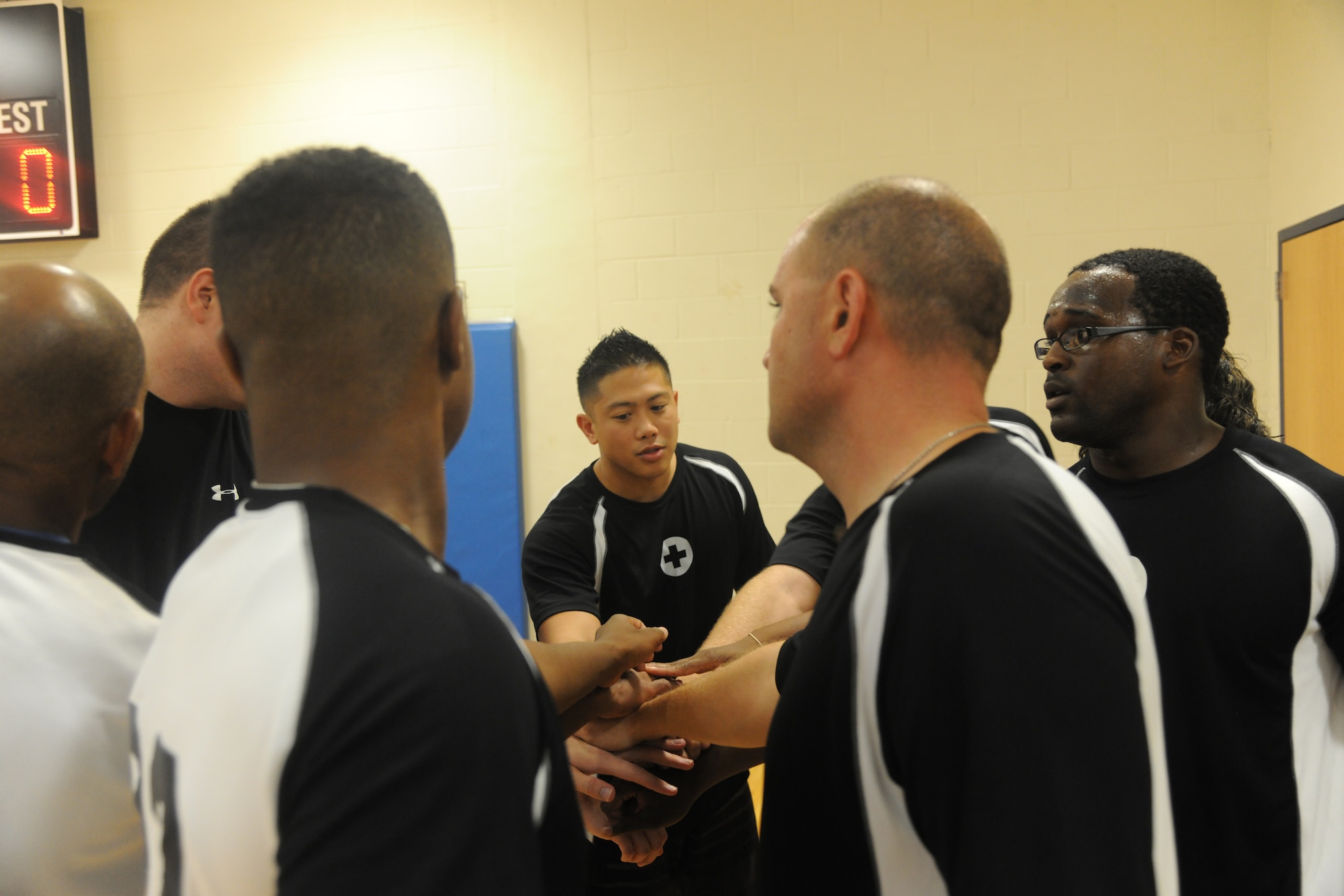 Joey Lee, 23rd Medical Group, center, leads his team in a pregame huddle before the start of an intramural volleyball championship game at Moody Air Force Base, Ga., Sept. 21, 2011. The team faced off against the 723rd Aircraft Maintenance Squadron. (U.S. Air Force photo by Airman 1st Class Paul Francis/Released)
