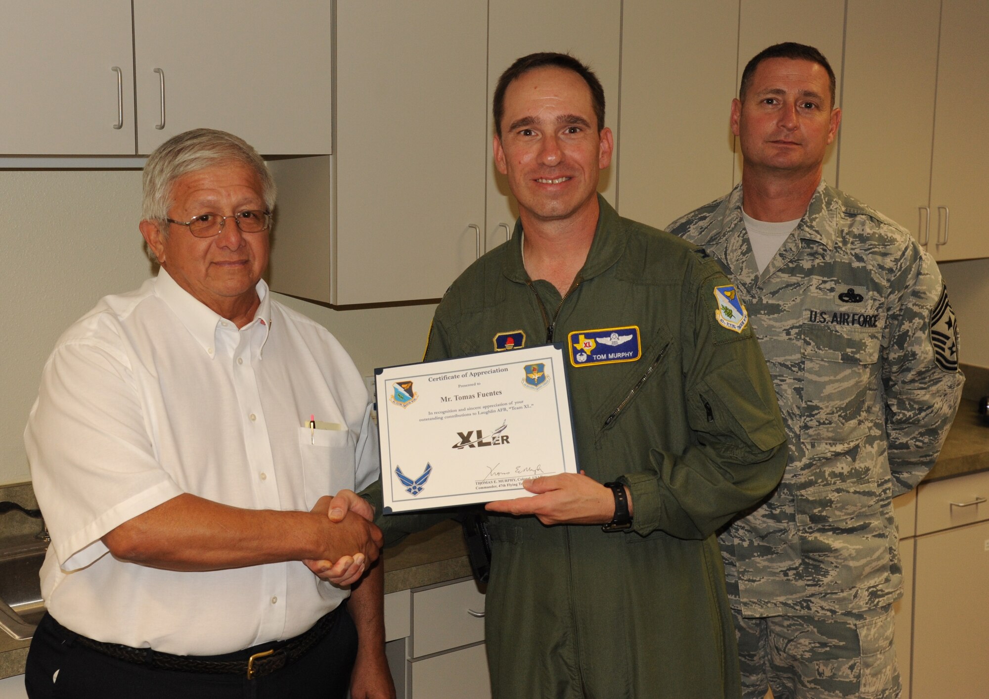 LAUGHLIN AIR FORCE BASE, Texas – Tomas Fuentes, 47th Maintenance Directorate, is awarded the XLer of the Week award by Col. Thomas Murphy, 47th Flying Training Wing commander, and Chief Master Sgt. Ray DeVite, 47th FTW command chief, at Laughlin’s Airfield Maintenance Operations Center Sept. 14. The XLer is a weekly award chosen by wing leadership and given to those who consistently make outstanding contributions to Laughlin and their unit. (U.S. Air Force photo/Airman 1st Class Blake Mize)