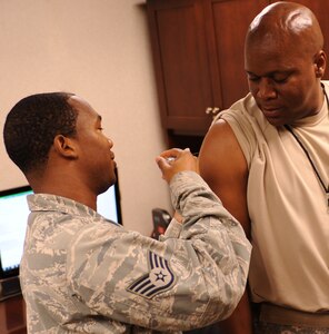 U.S. Air Force Staff Sgt. Mario Hartaway, 633rd Medial Operations Squadron aerospace medicine technician, administers a flu shot to U.S. Army Col. Reggie Austin, 633rd Air Base Wing vice commander, at Langley Air Force Base, Va., Sept. 22, 2011. The most effective way to prevent the majority of flu infections is through an annual vaccination combined with proper hand washing and cough etiquette. (U.S. Air Force photo by Airman 1st Class Teresa Cleveland/Released)