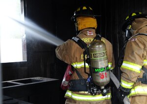 Matthew Brady, 11th Civil Engineer Squadron fire chief, uses the fire hose to create hydraulic ventilation, removing hot air and gases from the building where the fire was extinguished Sept. 12 at the Fire Emergency Services Training Area on Joint Base Andrews, Md.  The 11th CES fire emergency services perform these monthly live fire trainings to give firefighters essential training and experience. (U.S.  Air Force photo/Airman 1st Class Bahja J. Jones)