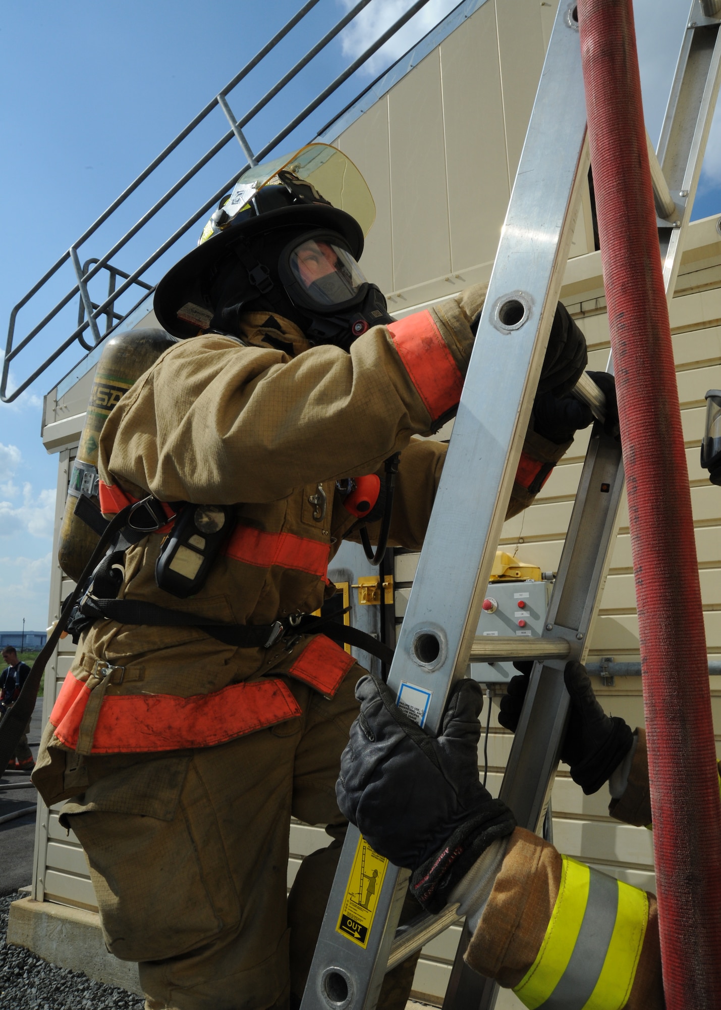 Airman 1st Class Travis Manchester, 11th Civil Engineer Squadron firefighter, climbs a ladder to the window of a building with a simulated basement fire at the Fire Emergency Services Training Area on Joint Base Andrews, Md., on Sept. 12. The 11th CES fire emergency services perform these monthly live fire trainings to give firefighters essential training and experience. (U.S.  Air Force photo/ Airman 1st Class Bahja J Jones)