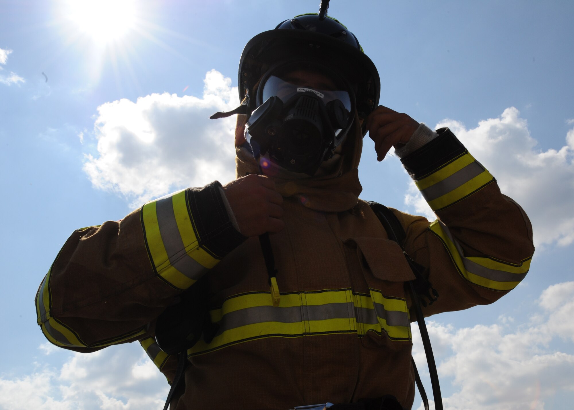 Senior Airman Joseph Galloway, 11th Civil Engineer Squadron firefighter, dons his helmet before a fire training Sept. 12 at the Fire Emergency Services Training Area on Joint Base Andrews, Md.  The 11th CES fire emergency services perform these monthly live fire trainings to give firefighters essential training and experience. (U.S.  Air Force photo/Airman 1st Class Bahja J. Jones)