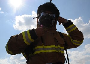 Senior Airman Joseph Galloway, 11th Civil Engineer Squadron firefighter, dons his helmet before a fire training Sept. 12 at the Fire Emergency Services Training Area on Joint Base Andrews, Md.  The 11th CES fire emergency services perform these monthly live fire trainings to give firefighters essential training and experience. (U.S.  Air Force photo/Airman 1st Class Bahja J. Jones)