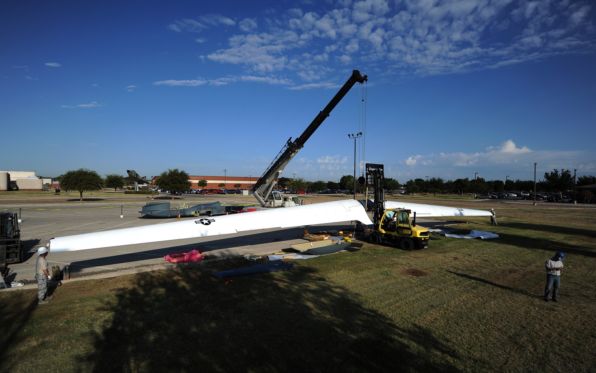 GOODFELLOW AIR FORCE BASE, Texas -- The 116 foot-long wings of the dismantled RQ-4 Global Hawk is hauled into the air by a crane as Airmen guide the wing Sept. 21. This is the first of the only two Global Hawks to be dismantled, and then reassembled as a static display. (U.S. Air Force photo/Airman 1st Class Michael Smith)
