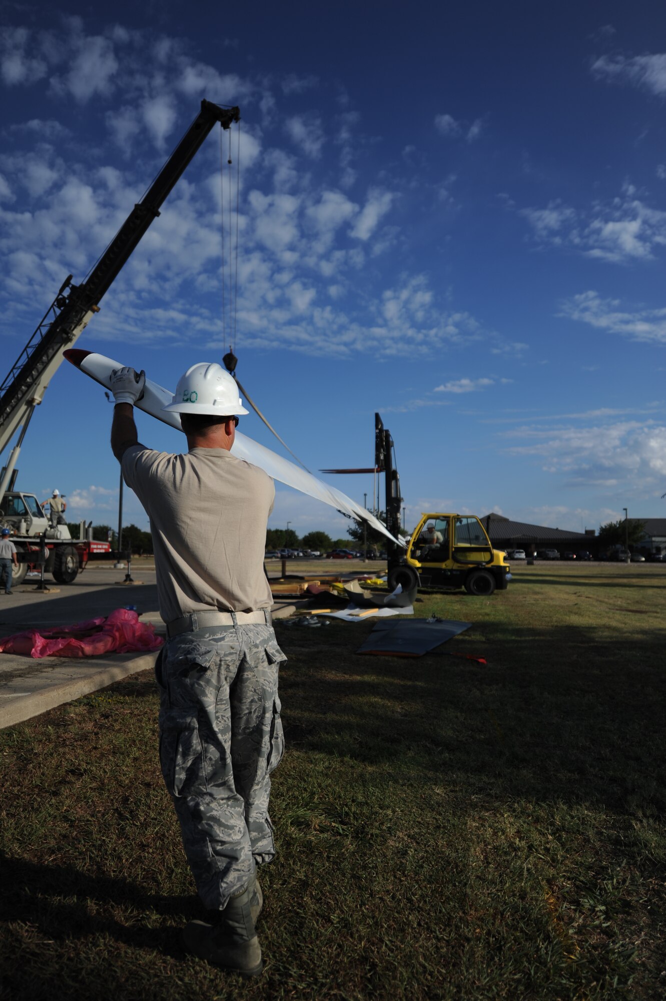 GOODFELLOW AIR FORCE BASE, Texas -- Staff Sgt. Brandon Gambrel, 76th Maintenance Wing, Tinker Air Force Base, Okla., guides the 116-foot-long wings of a dismantled RQ-4 Global Hawk  to the ground Sept. 21. This is the first of the only two Global Hawks to be dismantled, and then reassembled as a static display. (U.S. Air Force photo/Airman 1st Class Michael Smith)