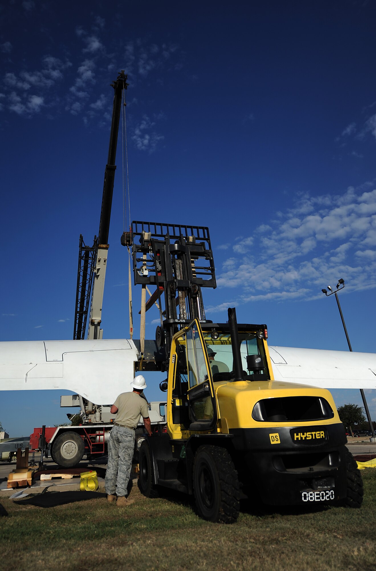 GOODFELLOW AIR FORCE BASE, Texas -- Staff Sgt.  Derek Bringham, 9th Civil Engineer Squadron ,Beale Air Force Base, Calif., guides the 116-foot-long wings of a dismantled RQ-4 Global Hawk onto a forklift Sept. 21. This is the first of the only two Global Hawks to be dismantled, and then reassembled as a static display. (U.S. Air Force photo/Airman 1st Class Michael Smith)