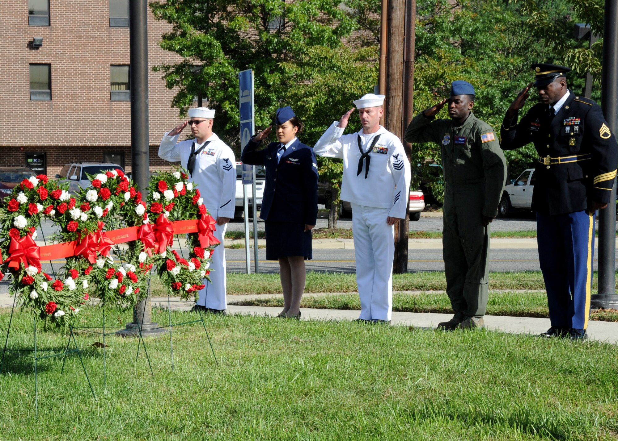 From left, Navy Petty Officer Petty Officer 1st Class Christopher Brandt, Naval Air Facility Washington  mobilization department leading petty officer; Airman  1st Class Vanessa Sanchez, 1st Airlift Squadron communication systems operator; Navy Petty Officer 2nd Class Matthew Mustico, NAF Washington administrative legal clerk; Staff Sgt. Anthony Montgomery, 1s AS special missions flight attendant; and Army Staff Sgt. Kevin Wright, Rockville Recruiting Station commander, salute during the POW/ MIA Remembrance Day ceremony Sept. 26 at the Airmen Memorial Museum in Suitland, Md. Each of the five wreaths represented Prisoners of War and service members Missing in Action from each branch of service. (U.S. Air Force photo/Airman 1st Class Bahja J. Jones) 