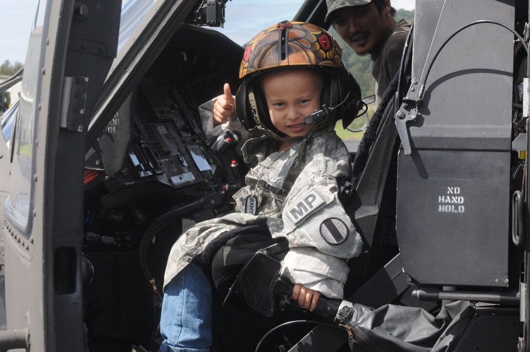 Five-year-old Wes Pak gives the thumbs up sign that all is a go before “take off” on the Blackhawk as his father, Nyong Pak, accompanies him on his “first flight.” Wes, who suffers from neuroblastoma cancer, received a first-class tour of Fort Eustis, getting the opportunity to live part of his dream of becoming a military pilot. (U.S. Army photo by Vicki Bowker/Released)