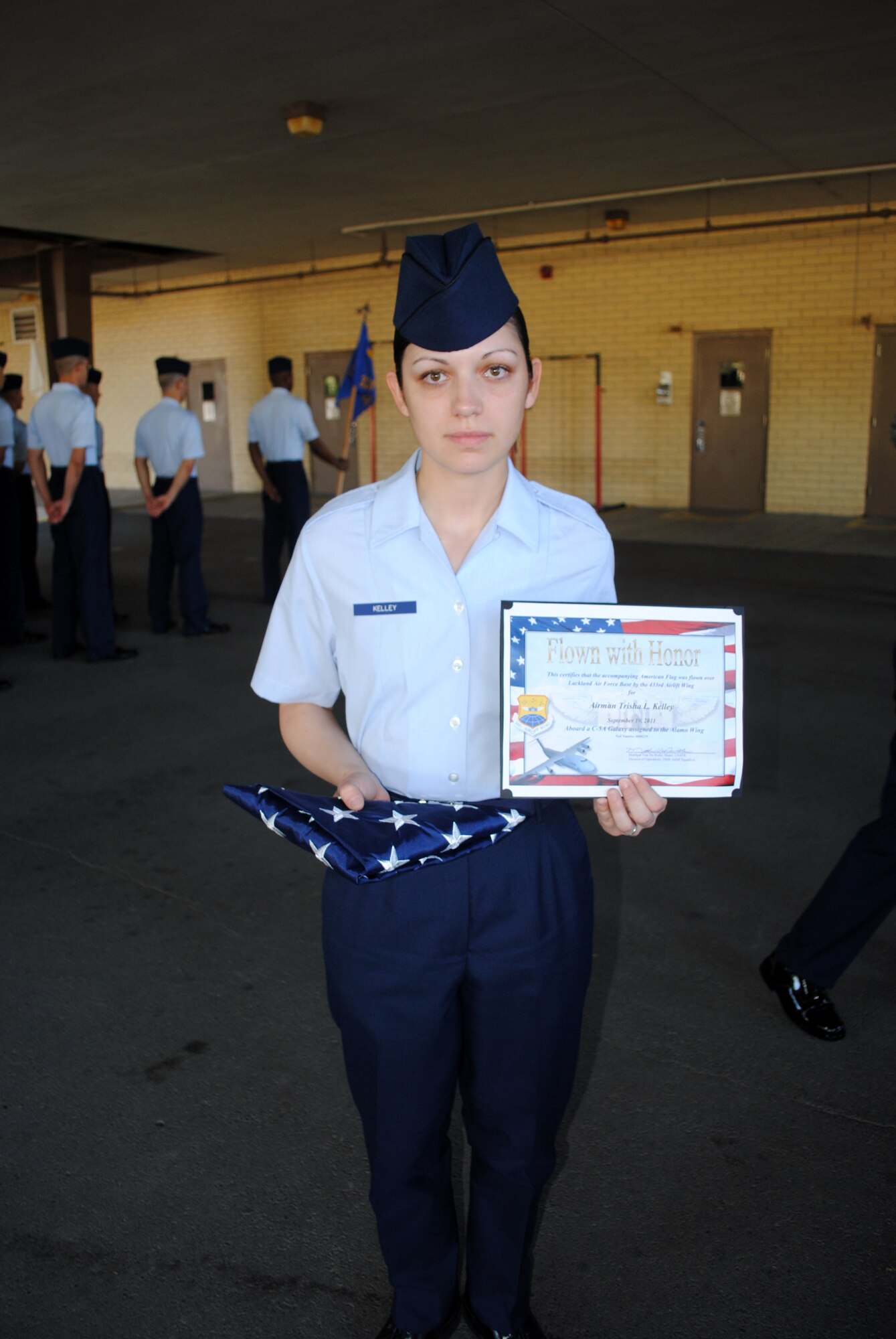 Airman Basic Trisha Kelley, 331st Training Squadron basic military training trainee, displays the American flag and commemorative certificate that were presented to her during a flight formation at the 331st TRS headquarters building, Sept. 22, 2011, at Lackland Air Force Base, Texas. 

The flag, presented as a surprise, was a gift on behalf of Airman Kelley’s husband, Senior Airman Justin Kelley, who is currently deployed to Southwest Asia. The flag was flown over Lackland AFB, Sept. 19, aboard a C-5A Galaxy assigned to the 433rd Airlift Wing.  

A commemorative certificate accompanied the flag. Both items were presented to the Airman Kelley in honor of her graduation from Air Force basic military training. (U.S. Air Force photo/Senior Airman Luis Loza Gutierrez) 