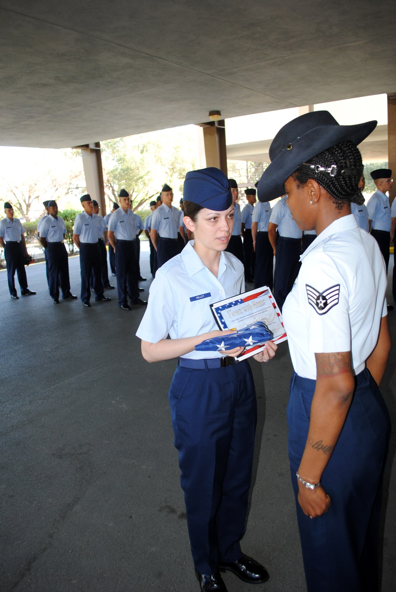 Staff Sgt. Tamisha Rutledge, 331st Training Squadron military training instructor, presents, Airman Basic Trisha Kelley, 331st TRS basic military training trainee, an American flag on the formation pad at the 331st TRS headquarters building, Sept. 22, 2011 at Lackland Air Force Base, Texas. 

The flag was presented as a surprise on behalf of Airman Kelley’s husband, Senior Airman Justin Kelley, who is currently deployed to Southwest Asia. The flag was flown over Lackland AFB on Sept. 19 aboard a C-5A Galaxy assigned to the 433rd Airlift Wing.  

A commemorative certificate accompanied the flag. Both items were presented to the Airman Kelley in honor of her graduation from Air Force basic military training. (U.S. Air Force photo/Senior Airman Luis Loza Gutierrez) 