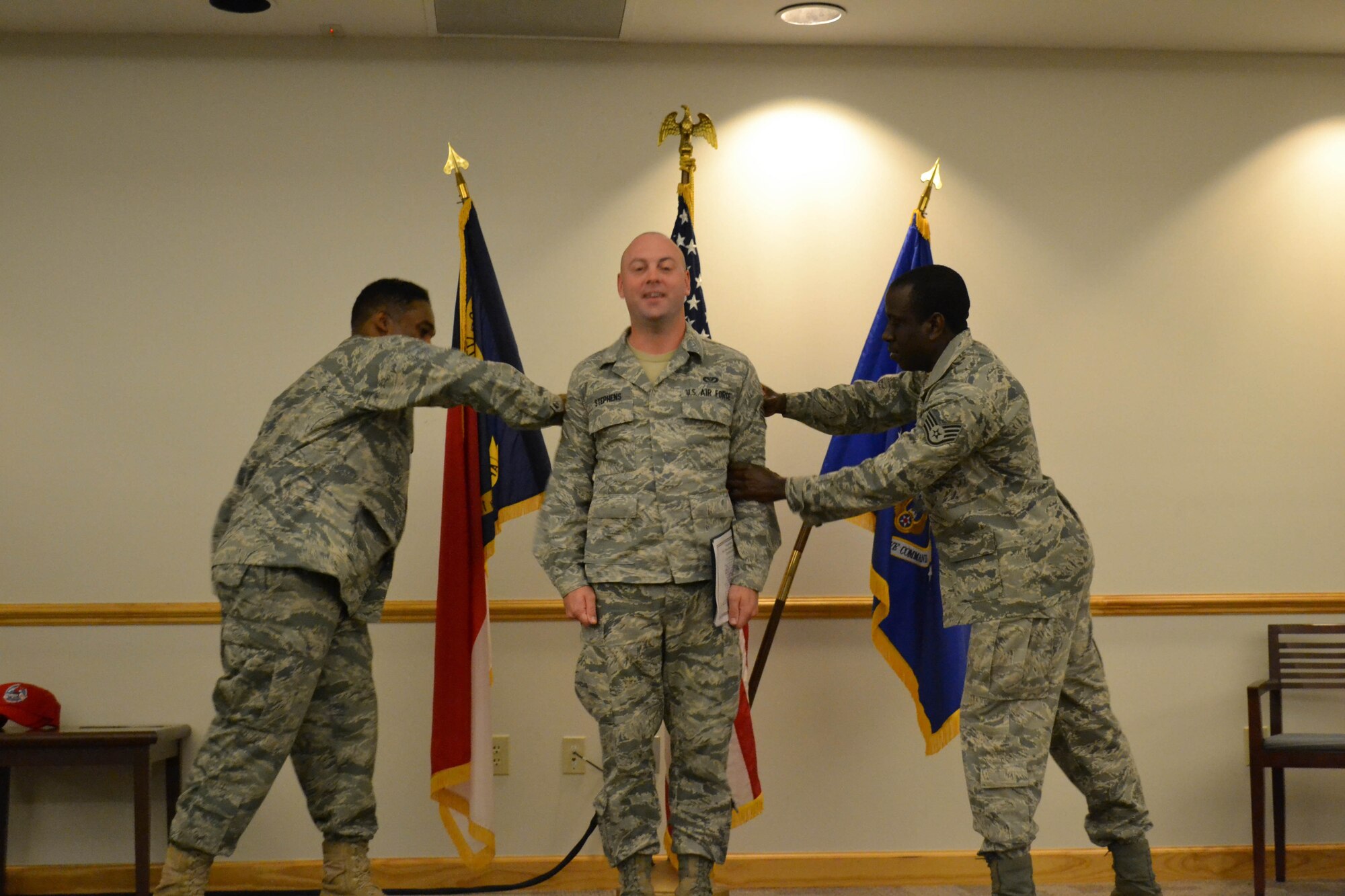 Airman First Class Joshua Stephens is promoted to the rank of senior airman..  Maj. Bryan Alston (left), current interim Red Horse commander, and supervisor Staff Sgt. Henry Jacobs do the honors of pinning on the new rank. (USAF photo courtesy of 567RHS)