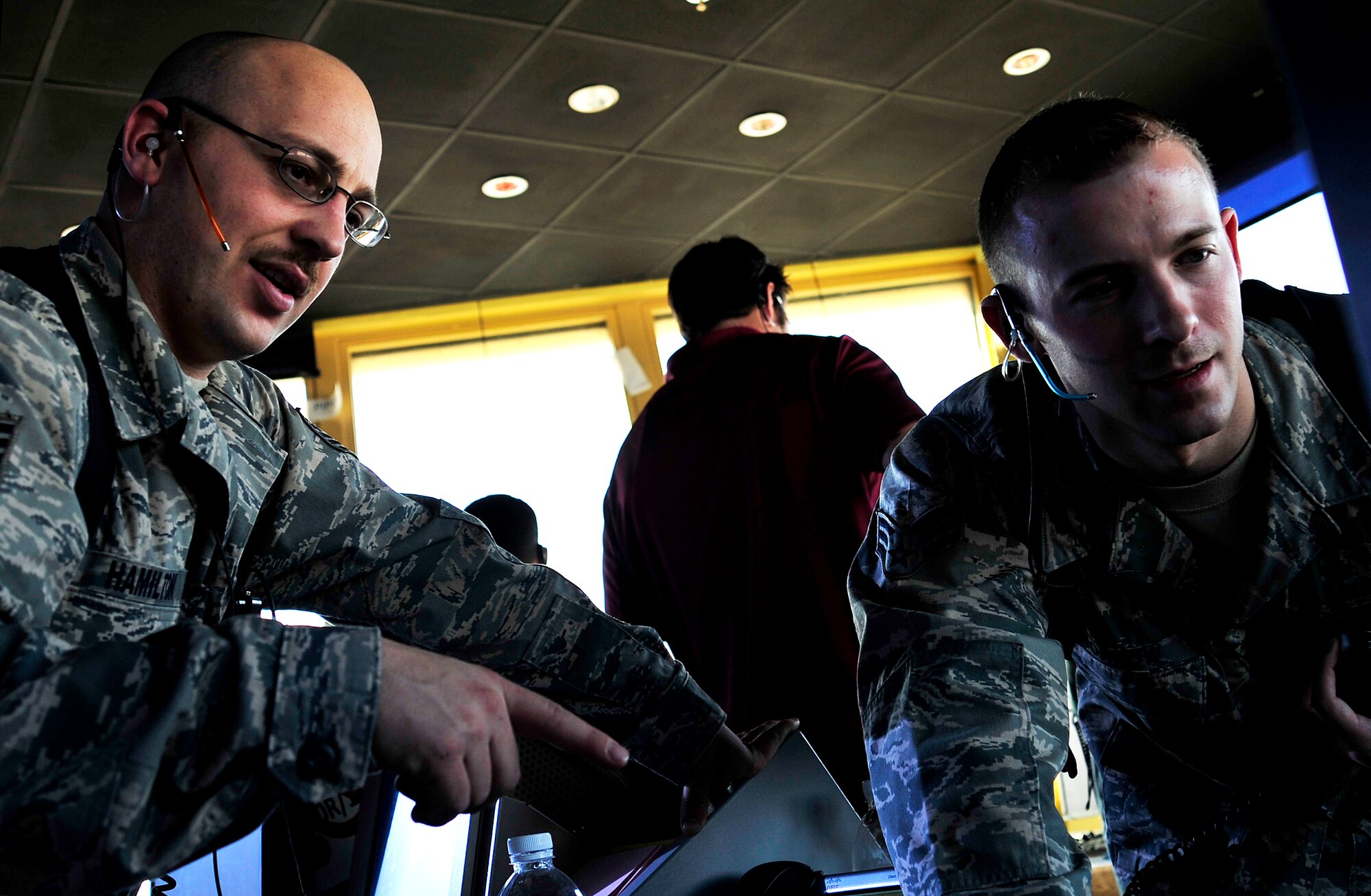 Tech. Sgt. Bryce Hamilton, left, and Senior Airman Matt Morrow discuss  aircraft approaching their air space in the control tower of Ali Base, Iraq, Aug. 27, 2011. Hamilton is a 407th Air Expeditionary Group air traffic control watch supervisor deployed from Offutt Air Force Base, Neb., and is from Charlotte, Iowa.  Morrow is a 407th AEG air traffic controller deployed from Barksdale Air Force Base, La., and his hometown is Cabot, Ark. (U.S. Air Force photo/Master Sgt. Cecilio Ricardo)