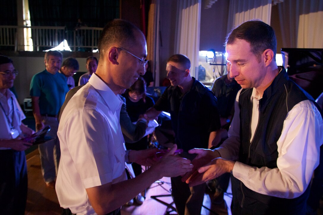 SENDAI, JAPAN--Major Michael Willen and SMSgt Michael Goetz exchange handshakes and bows at a pre-concert ceremony honoring relief workers’ heroic actions following the earthquake and tsunami.  Sept 2011. (photo: SSgt Josh Voyles)