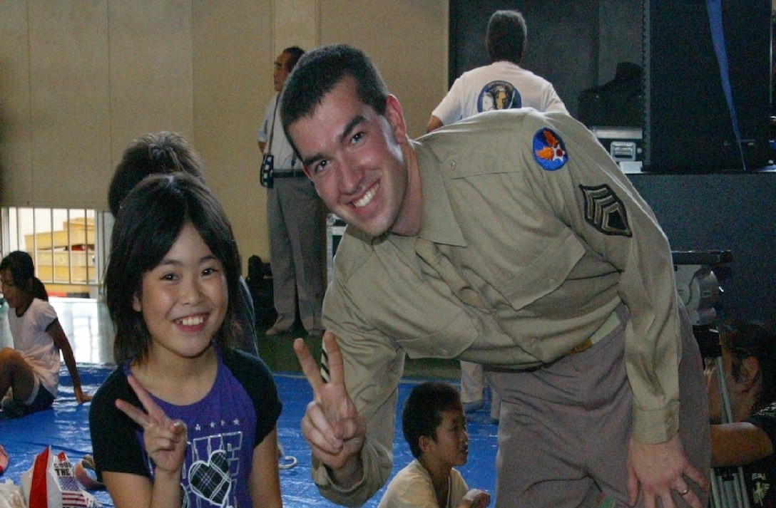 SENDAI, JAPAN--A1C Jordan Kimble snaps a picture with a young audience member. Sep 2011. (courtesy photo)