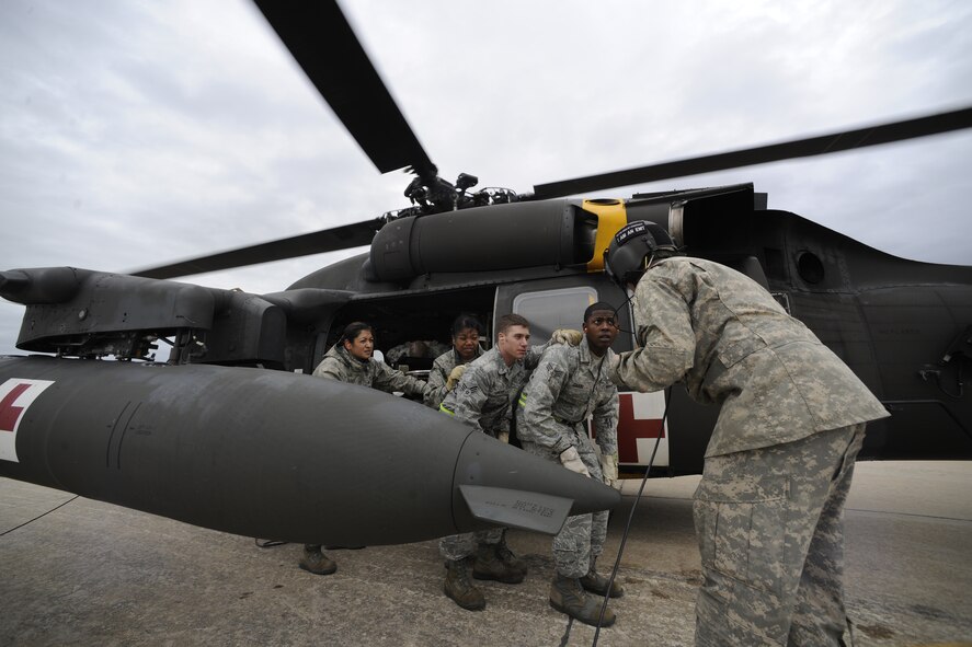 KUNSAN AIR BASE, Republic of Korea -- Army Spc. James Donnel, a flight medic with C Co. 3/2 General Support Aviation Battalion at Camp Humphreys, guides members of the 8th Medical Group with a patient to a UH-60 Blackhawk helicopter during their medical evacuation training here Sept. 19. Army flight medics from Camp Humphreys visited the Wolf Pack to familiarize the medics with the medevac concept. (U.S. Air Force photo/Staff Sgt. Rasheen A. Douglas)