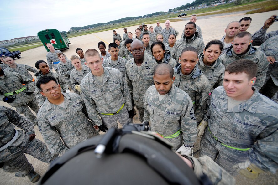 KUNSAN AIR BASE, Republic of Korea -- Members of the 8th Medical Group listen to a safety briefing before their hot loading session of their medical evacuation training starts here Sept. 19. The medevac training focused on cold and hot loading, which is loading patients onto the helicopter with the rotor off for cold loading, and on for hot loading. Army flight medics from Camp Humphreys visited the Wolf Pack to familiarize the medics with the medevac concept. (U.S. Air Force photo/Staff Sgt. Rasheen A. Douglas)