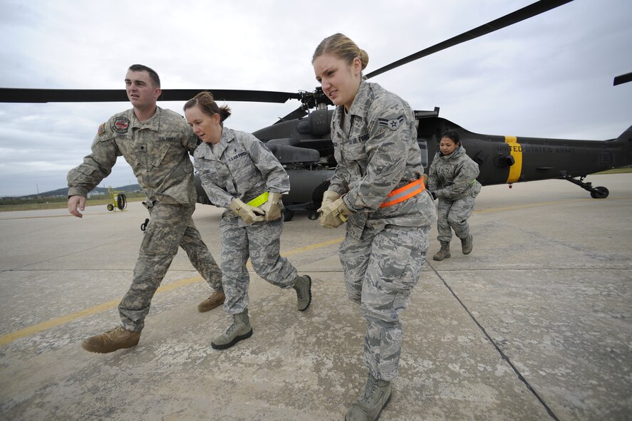 KUNSAN AIR BASE, Republic of Korea -- Members of the 8th Medical Group unload a patient from UH-60 Blackhawk helicopter during the cold loading session of their during medical evacuation training here Sept. 19. The medevac training focused on cold and hot loading, which is loading patients onto the helicopter with the rotor off for cold loading, and on for hot loading. Army flight medics from Camp Humphreys visited the Wolf Pack to familiarize the medics with the medevac concept. (U.S. Air Force photo/Staff Sgt. Rasheen A. Douglas)