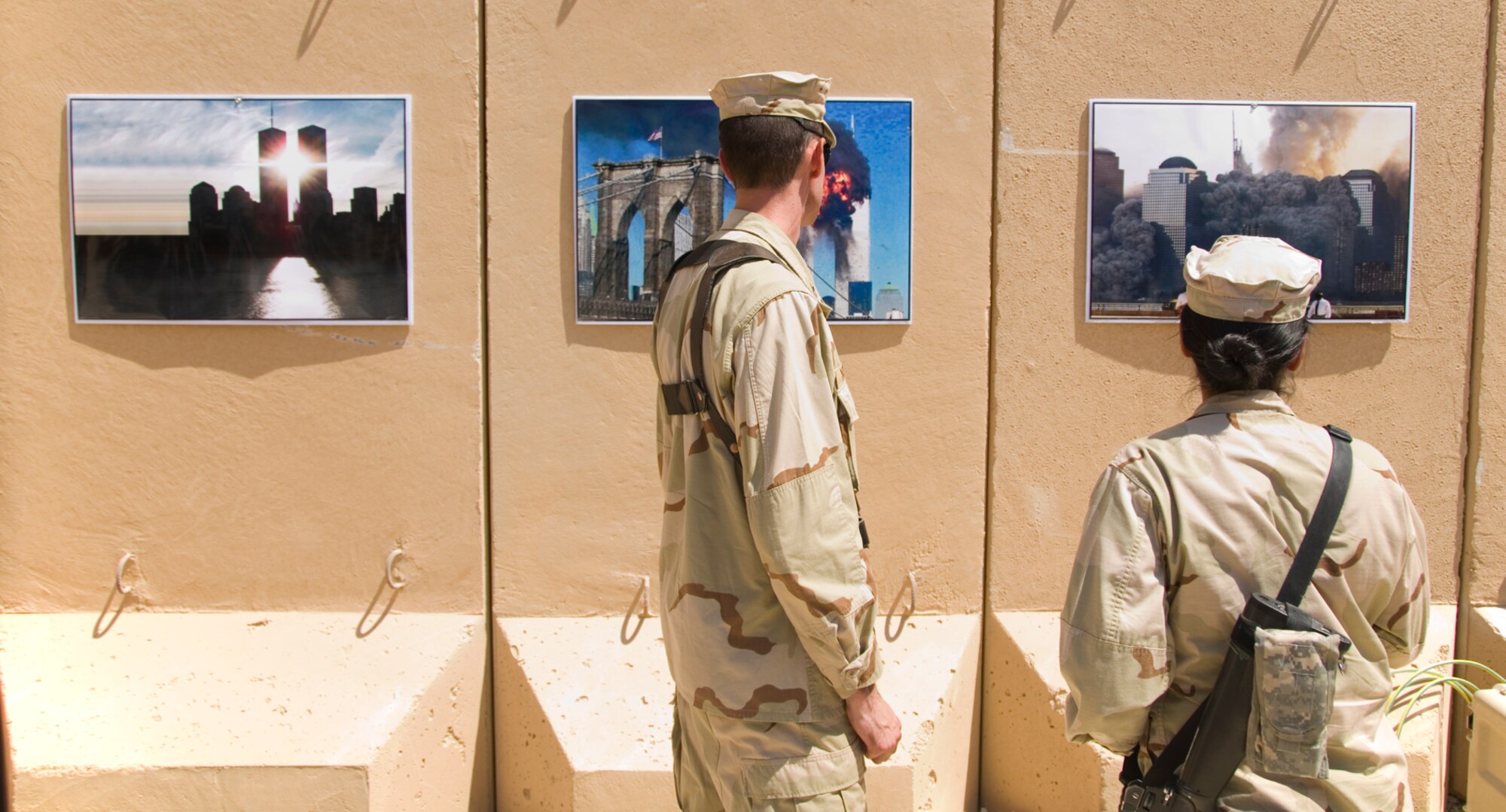 Navy service members look at posters at the 9/11 Remembrance Ceremony on Al Asad Air Base, Iraq Sept. 11, 2011. The ceremony remembers the terrorists attacks on Sept. 11, 2001. (U.S. AIr Force photo/Staff Sgt. Shawn Rose)