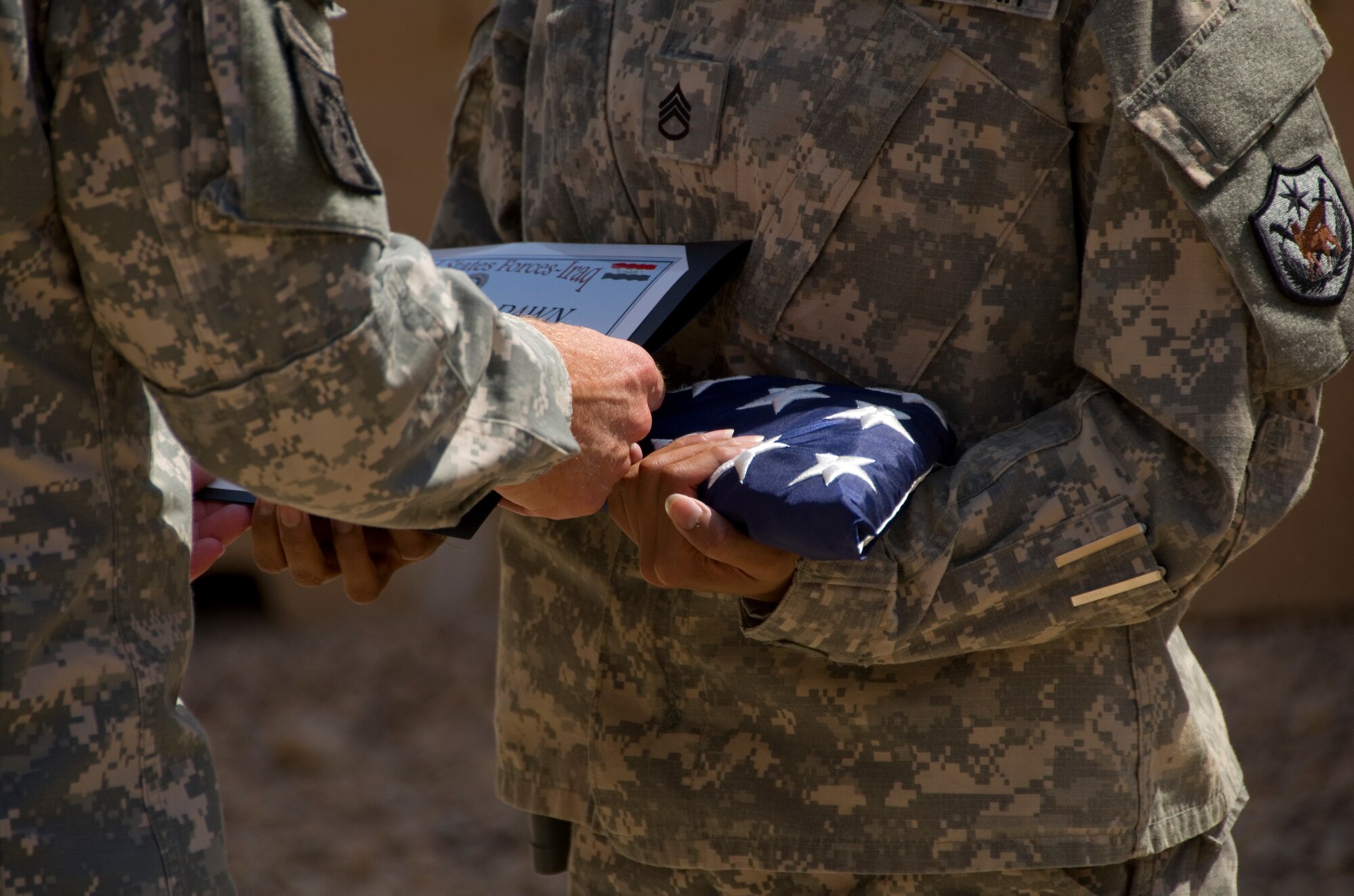 Army Lt. Gen. Frank Helmick, Deputy Commanding General for Operations, United States Forces - Iraq, presents Army Staff Sgt. Luz Guzman with a flag and certificate at the 9/11 Remembrance Ceremony on Al Asad Air Base, Iraq Sept. 11, 2011. Guzman is an executive administrative assistant, deployed from Ft. Bragg, NC. (U.S. AIr Force photo/Staff Sgt. Shawn Rose)