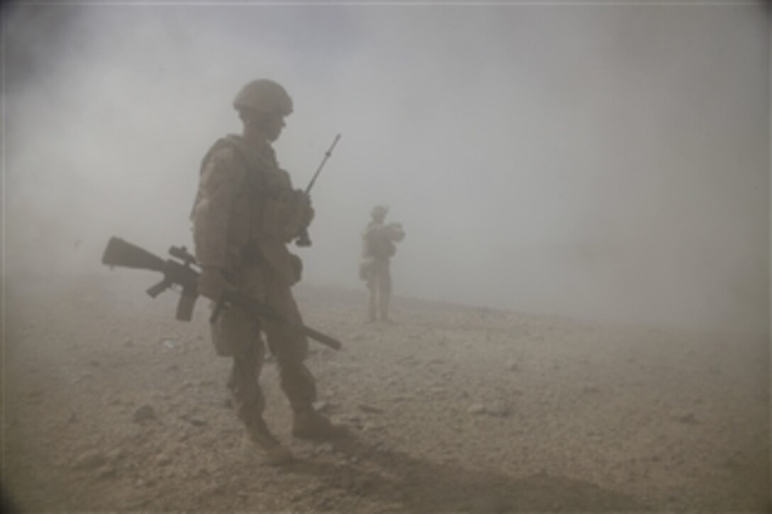 U.S. Marine Corps Sgt. Calvin Nash waits for the dust to clear after a controlled detonation during a patrol in Sangin, Afghanistan, on Sept. 8, 2011.  The Marines are using the explosives to destroy abandoned compounds that block views from security posts.  Nash is a squad leader with 3rd Platoon, Alpha Company, 1st Battalion, 5th Marines, Regimental Combat Team 8.  
