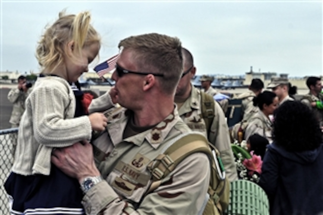 Navy Lt. Cmdr. Karl Haywood reunites with his daughter after returning from an eight-month deployment in Iraq on Naval Air Station North Island, San Diego, Sept. 18, 2011. Haywood is assigned to Explosive Ordnance Disposal Group 1.