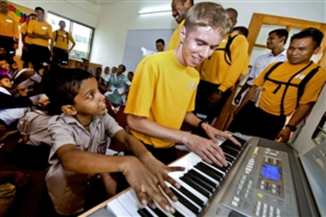 U.S. Navy Petty Officer 3rd Class William Hodgin plays the piano with a student in the music room at the Bangladesh Ashar Alo School and Rehabilitation Center during a community service project as part of Cooperation Afloat Readiness and Training 2011 in Chittagong, Bangladesh, Sept. 20, 2011. Hodgin is assigned to the USS Defender. The annual bilateral exercises in Southeast Asia are designed to strengthen relationships and enhance force readiness. 
