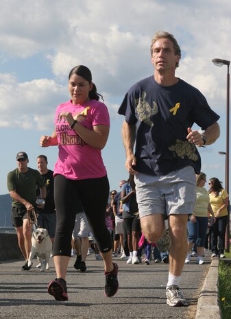 Sgt. Andrea M. Olguin, a station combat photographer, and Tony J. Lewis, a runner, take part in the 5 kilometer Suicide Awareness and Prevention Walk/Run at the sea wall here Sept. 23. As of August 2011, there have been 23 suicides and 125 attempted suicides within the Marine Corps. The purpose of the event was to raise station residents’ awareness of suicide, the warning signs and ways to prevent it.