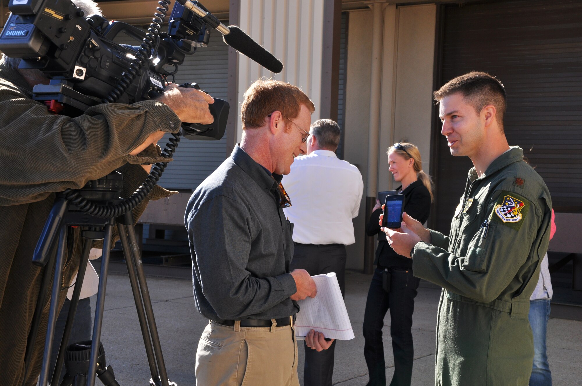 Maj. David DeAngelis, 419th Fighter Wing pilot, shows a picture of his son to a local reporter before joining his comrades on a plane headed for the Asia-Pacific region Sept. 23. Nearly 200 Airmen deployed for 180 days, including about 75 reservists from the 419th FW. (U.S. Air Force photo/Bryan Magaña)