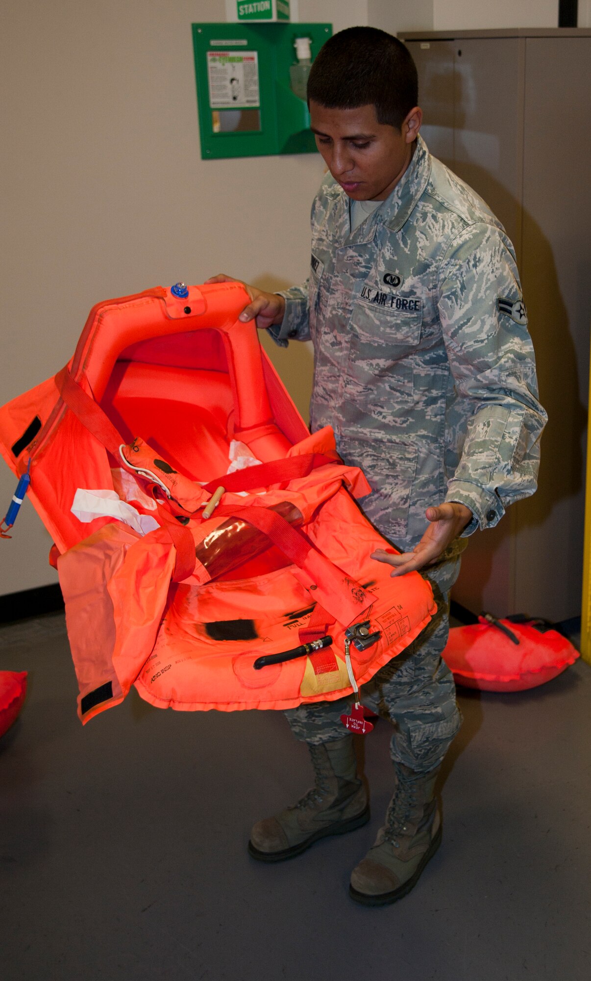 Airman 1st Class Federick Gutierrez, 22nd Operations Support Squadron Aircrew Flight Equipment journeyman, demonstrates how to use a floating infant cot, Aug. 23, 2011, McConnell Air Force Base, Kan. Along with servicing floatation devices, Airmen from the AFE ensure all lifesaving equipment for the 63 KC-135 Stratotanker at McConnell is made operational. (U.S. Air Force photo by Airman 1st Class Armando A. Schwier Morales)