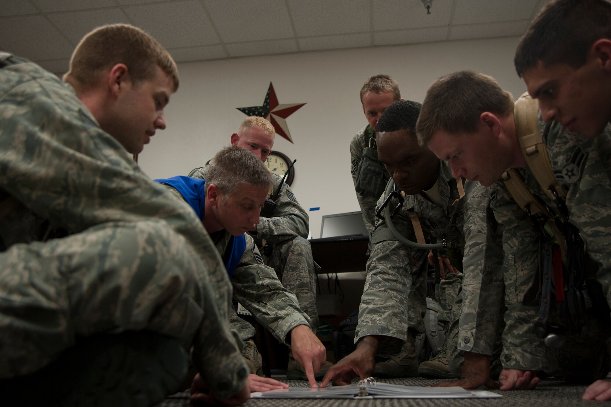 (Center) Master Sgt. Michael Stewart, 22nd Operations Support Squadron Aircrew Flight Equipment Quality Assurance superintendent, discusses proper set up of the Aircrew Contamination Control Area Aug. 7, 2011, McConnell Air Force Base, Kan. The ACCA decontaminates aircrew members after a chemical attack. (U.S. Air Force photo by Airman 1st Class Armando A. Schwier Morales)