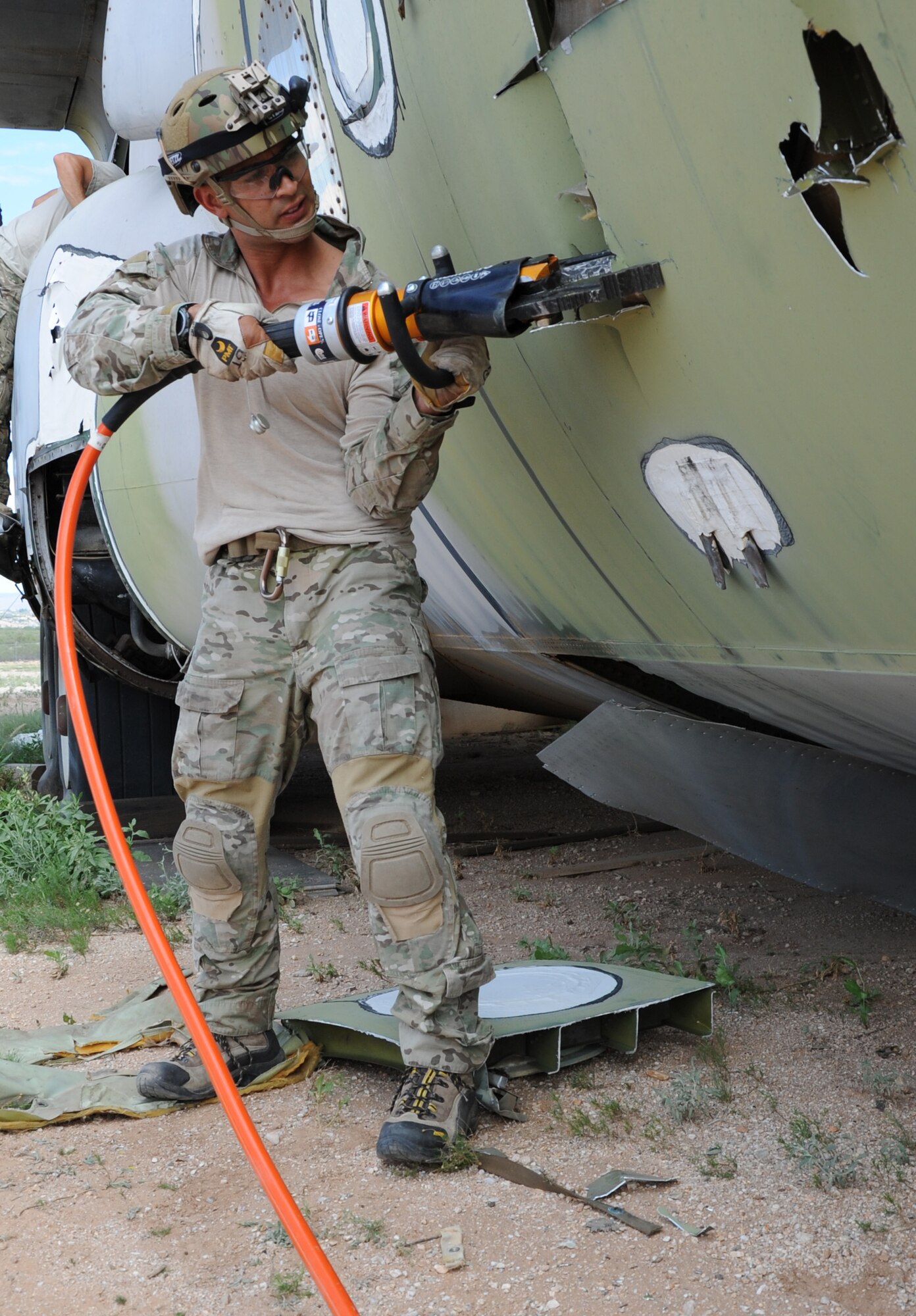 Staff Sgt. Ryan Gilbert, a pararescueman with the 306th Rescue Squadron, utilizes the Jaws of Life to cut into a C-130 Hercules during the unit’s ROCO training exercise. Pararescuemen with the 306th RQS practiced extraction techniques on a C-130 inside the bone yard at Davis-Monthan Air Force Base, Ariz. (U.S. Air Force Photo/ Tech. Sgt. Luke Johnson)