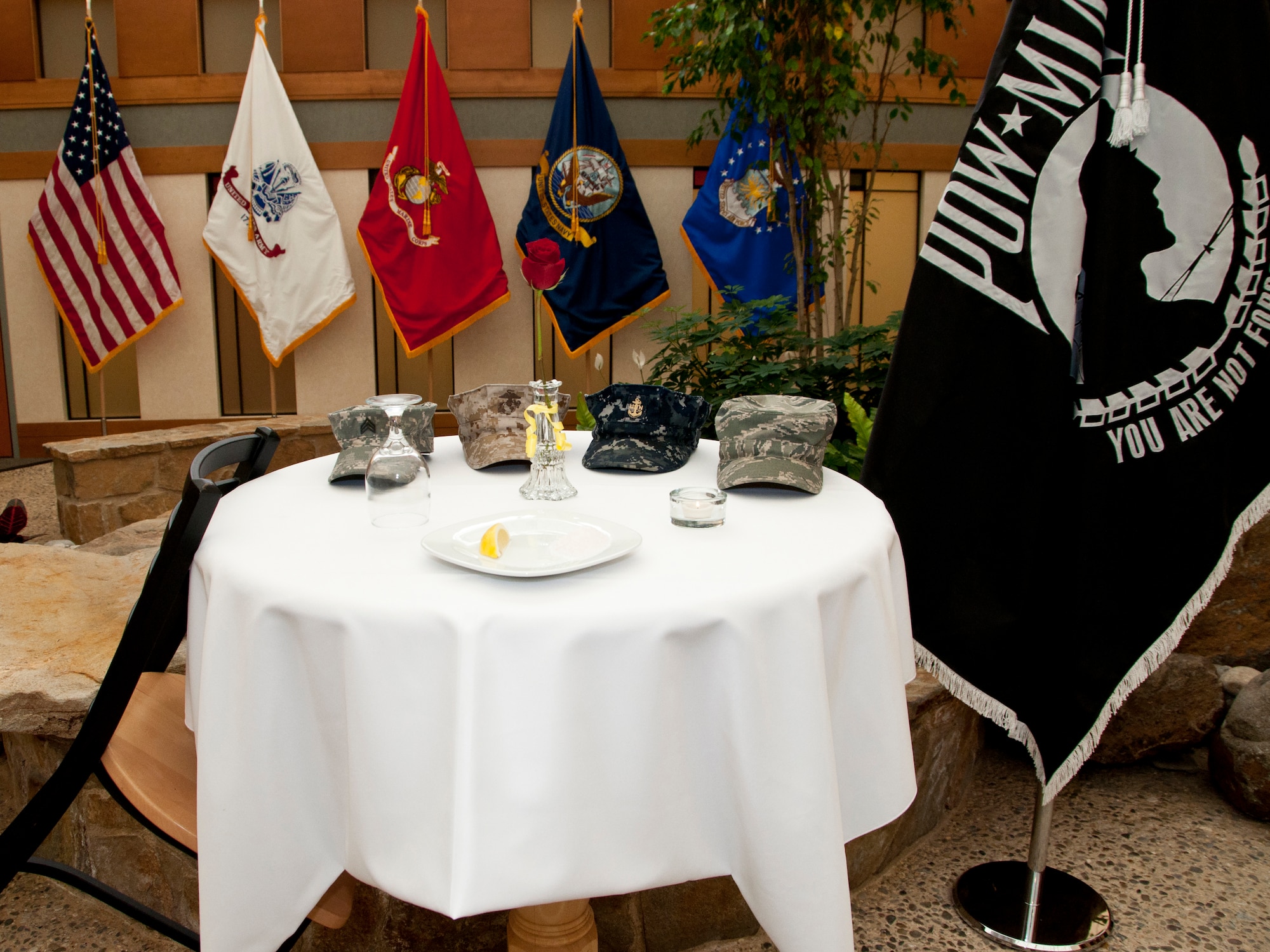 Four branches of the Armed Forces were represented during the Air Force Mortuary Affairs Operations' Prisoner of War Missing in Action ceremony Sept. 23 inside the Atrium. One member from the Army, Navy, Marines and Air Force placed their hat on the table to symbolize the sacrifices of each of the Armed Forces. (U.S. Air Force photo by Augustine G. Salazar)