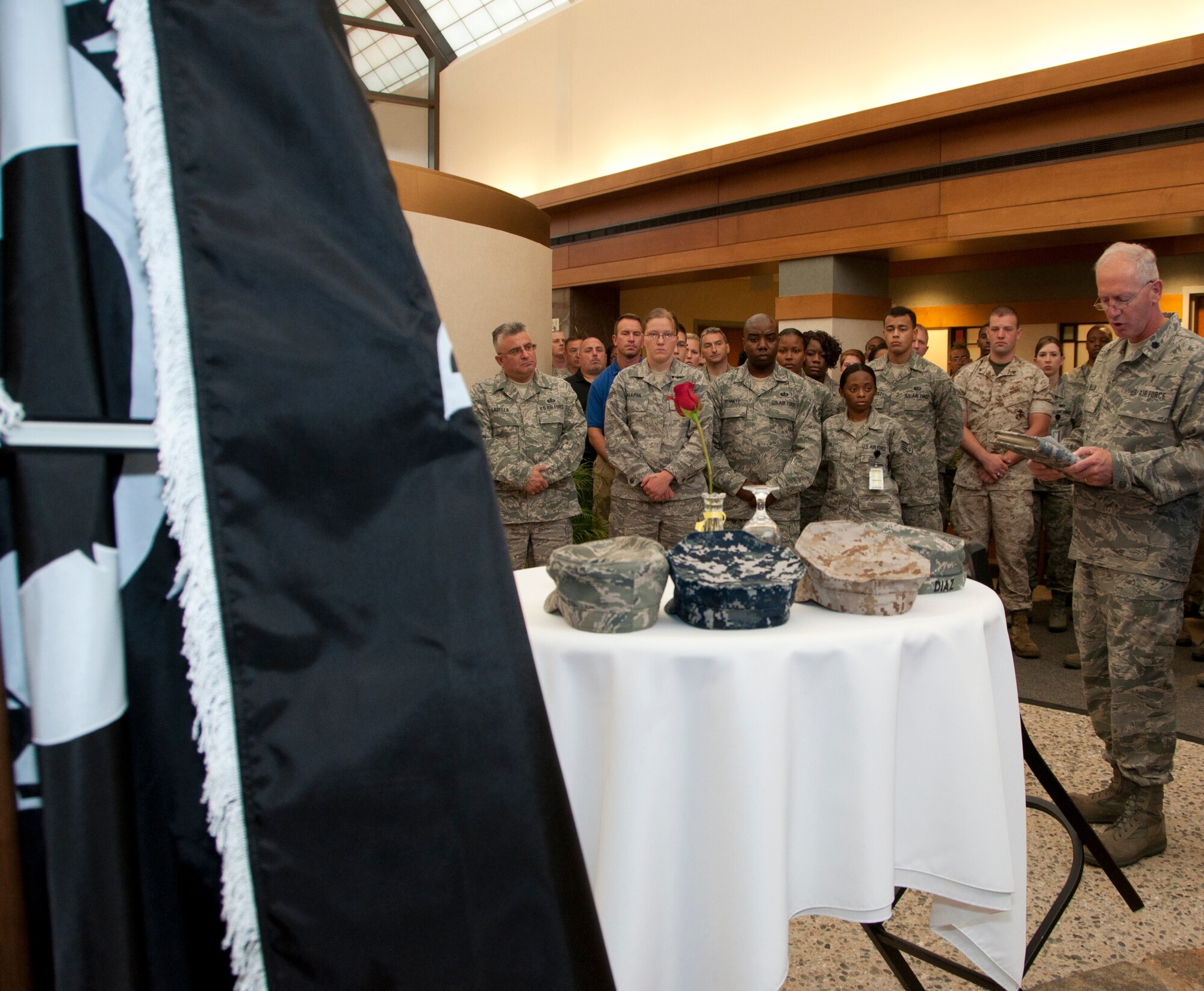 Lt. Col. David Allen (far right), an Air Force Mortuary Affairs Operations chaplain, delivers a speech regarding the symbolism displayed on a table honoring prisoners of war and missing in action servicemembers during a Sept. 23 ceremony inside the Atrium. The glass was inverted for the thousands of MIA servicemembers who could not toast on this occasion. (U.S. Air Force photo by Augustine G. Salazar)