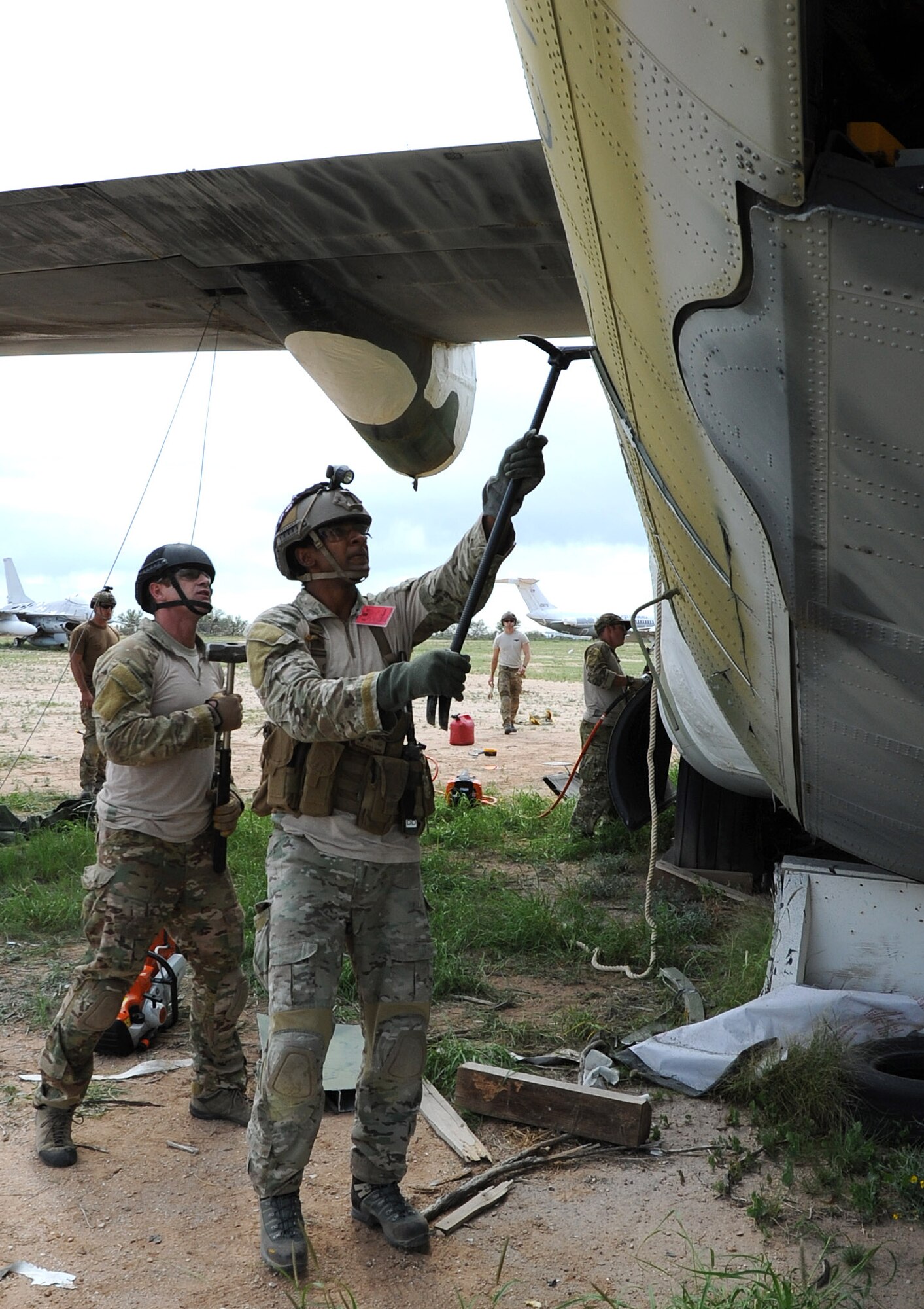 Staff Sgt. Richard Dunn, a pararescueman with the 306th Rescue Squadron, preys open the side of a C-130 Hercules as a pararescueman with the California Air National Guard 129th Rescue Wing observes, during the squadron’s ROCO training exercise. Pararescuemen with the 306th RQS and the 129th RQW had the rare opportunity to practice extraction techniques on a C-130. (U.S. Air Force Photo/ Tech. Sgt. Luke Johnson)